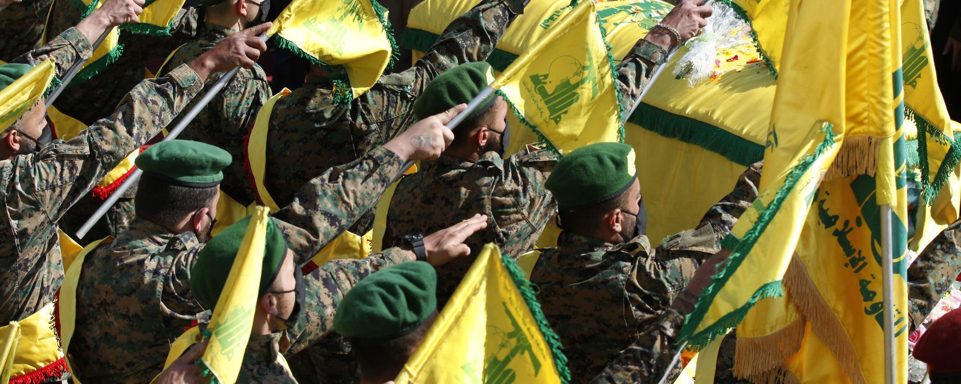 Hezbollah fighters raise their group flags, as they salut the coffin of their comrade Mohammed Tahhan who was shot dead on Friday by Israeli forces along the Lebanon-Israel border, during his funeral procession, in the southern village of Adloun, Lebanon, Saturday, May 15, 2021 - Sputnik International, 1920, 03.06.2024
