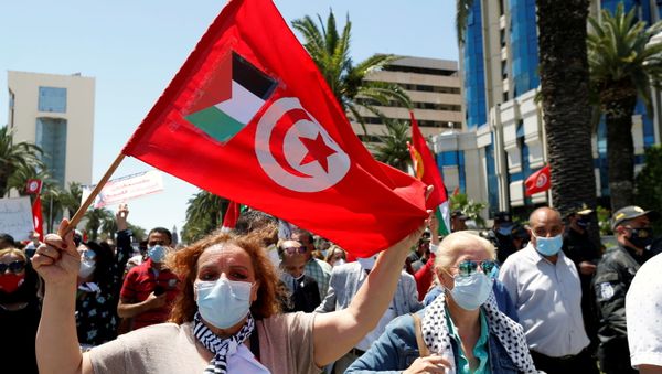 A demonstrator holds a Tunisia flag with a Palestinian flag attached during a protest to express solidarity with the Palestinian people, in Tunis, Tunisia, May 19, 2021. - Sputnik International