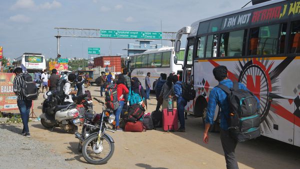 People wait on the outskirts of Bangalore to board buses and return to their home towns on the border of the states of Karnataka and Tamil Nadu, as another lockdown looms to tackle the surge in COVID-19 coronavirus cases on 13 July 2020. - Sputnik International
