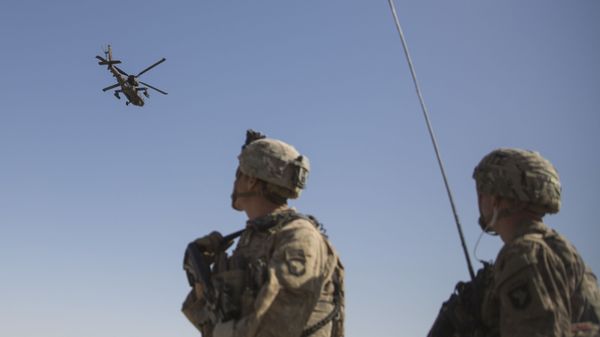 This June 10, 2017 photo released by the U.S. Marine Corps shows an AH-64 Apache attack helicopter provides security from above while CH-47 Chinooks drop off supplies to U.S. Soldiers with Task Force Iron at Bost Airfield, Afghanistan. - Sputnik International