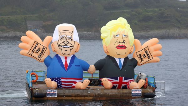 Inflatable dummies depicting U.S. President Joe Biden and Britain's Prime Minister Boris Johnson are displayed on a pontoon floating off Gyllyngvase Beach during an action organized by Crack the Crisis, in Falmouth, on the sidelines of G7 summit in Cornwall, Britain, June 11, 2021.  - Sputnik International