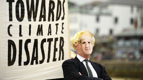 Environmental activist from Extinction Rebellion wears a face masks of Britain's Prime Minister Boris Johnson takes part in a photocall in St Ives on June 11, 2021 during the G7 summit.  - Sputnik International