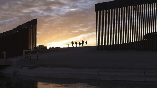 A pair of migrant families from Brazil pass through a gap in the border wall to reach the United States after crossing from Mexico in Yuma, Ariz., Thursday, June 10, 2021, to seek asylum. - Sputnik International