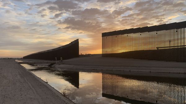 The sun sets above the U.S.-Mexico border wall, seen in Yuma, Ariz., Wednesday, June 9, 2021. - Sputnik International