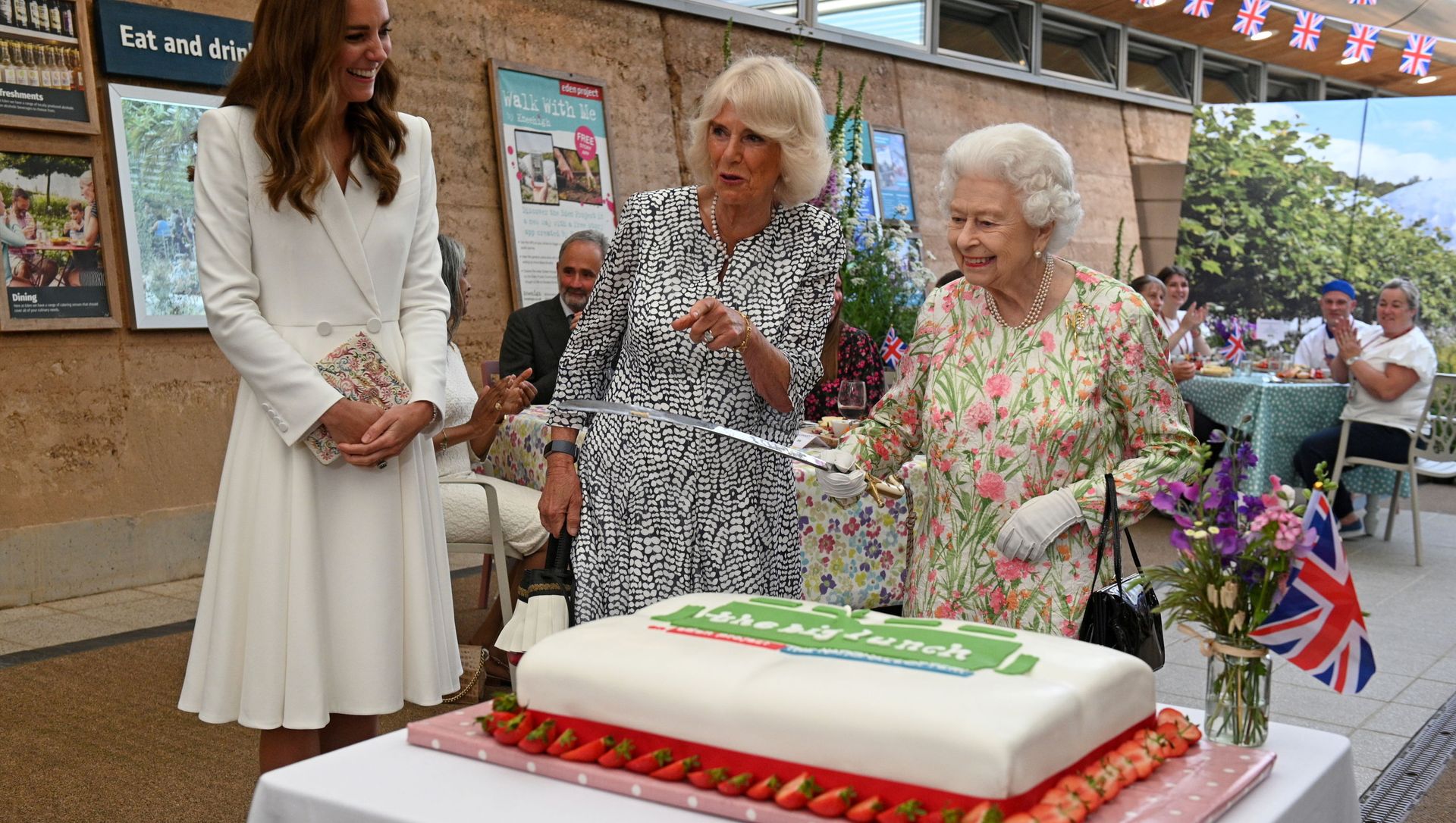 Britain's Queen Elizabeth holds a sword in order to cut a cake next to Catherine, the Duchess of Cambridge and Camilla, Duchess of Cornwall Britain's Queen Elizabeth holds a sword in order to cut a cake next to Catherine, the Duchess of Cambridge and Camilla, Duchess of Cornwall - Sputnik International, 1920, 12.06.2021