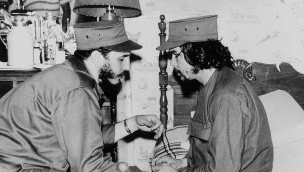 (FILES)This 1959 file photo shows Cuban Fidel Castro (L), then 33 years old, chatting with ailing 31-year-old Ernesto Che Guevara, at his barracks in Havana, shortly after both led the revolution that overthrew the Batista regime.  - Sputnik International