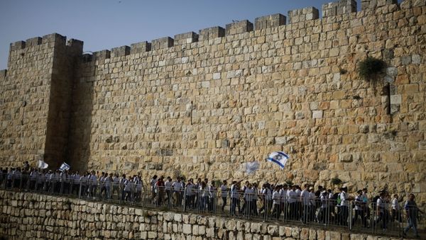 Youths wave Israeli flags during a parade marking Jerusalem Day amid Israeli-Palestinian tension as they march along the walls surrounding Jerusalem's Old City, May 10, 2021. REUTERS/Nir Elias/File Photo - Sputnik International