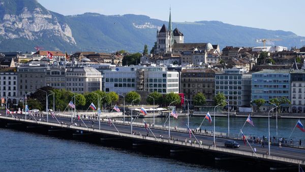 People cross a bridge decorated with United States and Russian flags in Geneva, Switzerland, Tuesday, June 15, 2021. US President Joe Biden is scheduled to meet with Russian President Vladimir Putin in Geneva, Wednesday, June 16, 2021 - Sputnik International