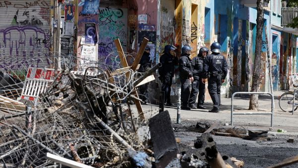 Police officers stand near extinguished barricades at Rigaer Street in Berlin, Germany, June 16, 2021 - Sputnik International