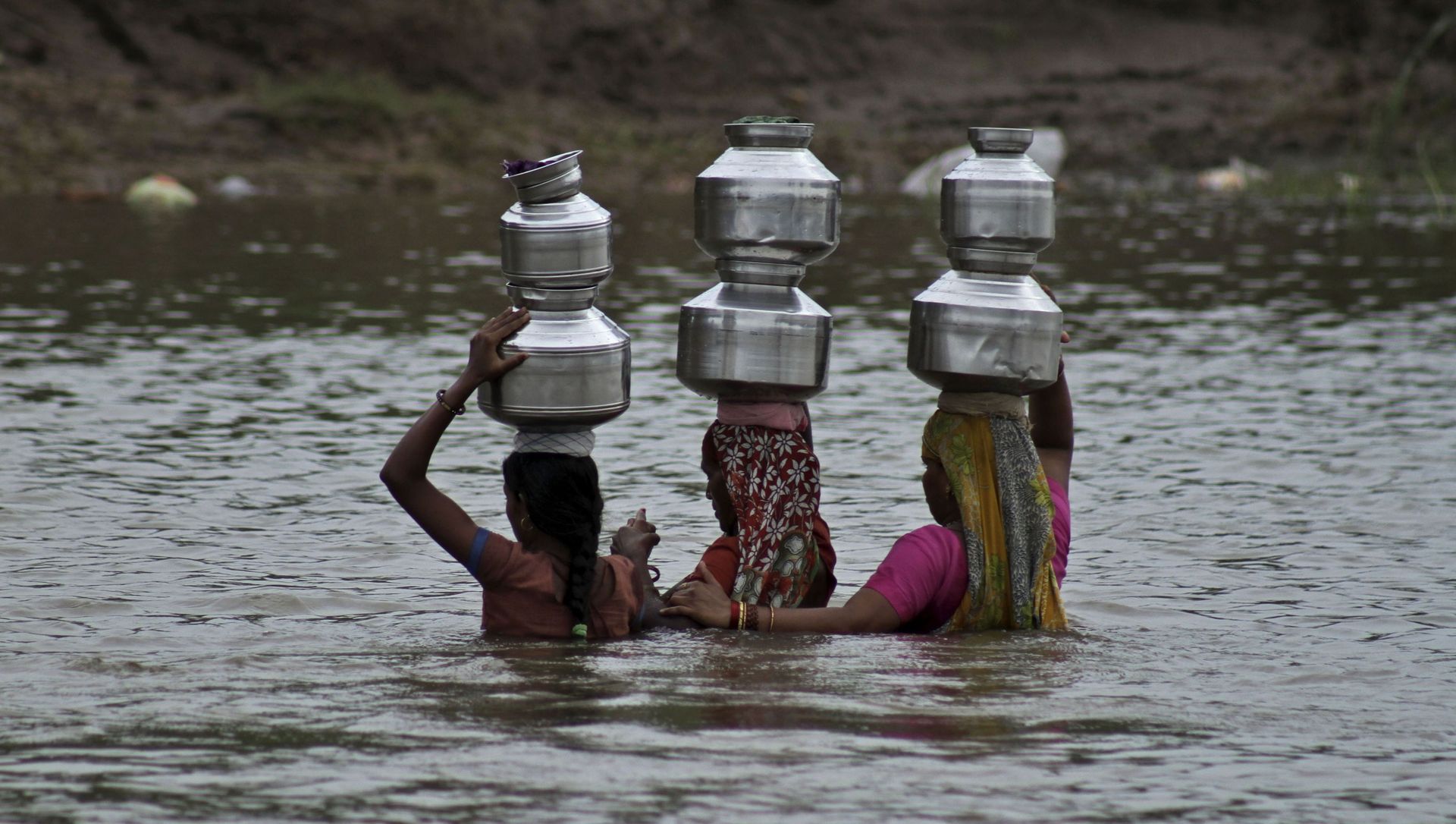 Indian women hold each other as they cross the River Heran after collecting drinking water near Sajanpura village in Chhota Udepur district of Gujarat state, India, Tuesday, Aug. 5, 2014 Indian women hold each other as they cross the River Heran after collecting drinking water near Sajanpura village in Chhota Udepur district of Gujarat state, India, Tuesday, Aug. 5, 2014 - Sputnik International, 1920, 18.06.2021