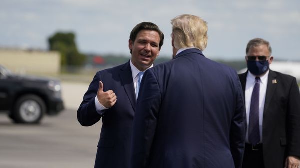 President Donald Trump speaks with Florida Gov. Ron DeSantis as he arrives at Southwest Florida International Airport, Friday, Oct. 16, 2020, in Fort Myers, Fla - Sputnik International
