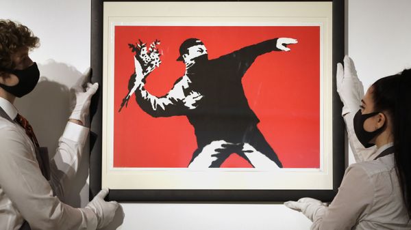 Gallery technicians display a Banksy called Love is in the Air screenprint in colours, 2003, on wove paper, numbered 412/500 in pencil at Christie's auction rooms in London, Friday, March 26, 2021 - Sputnik International