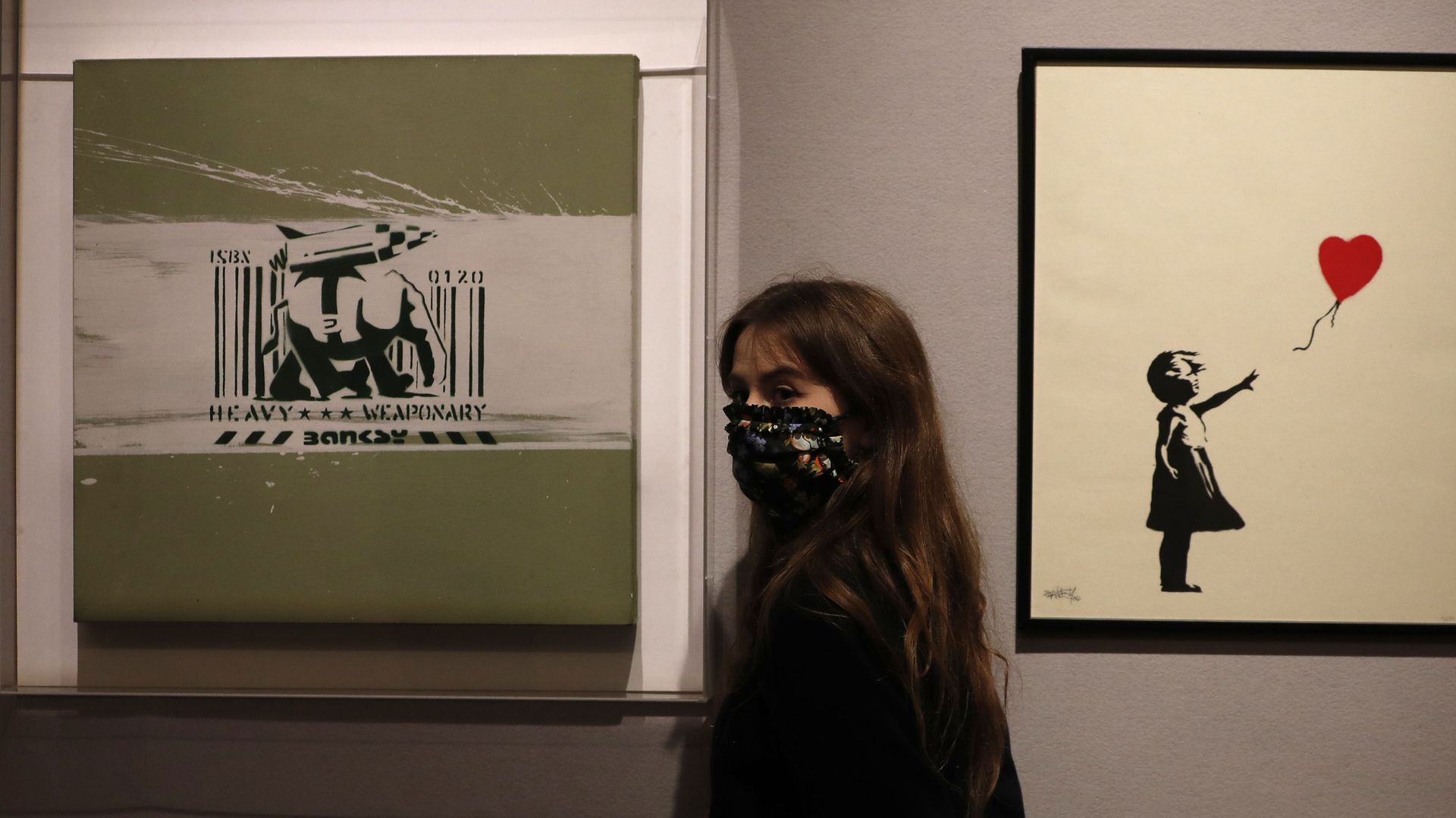 A member of staff from Bonhams auction house stands between two works by British artist Banksy 'Girl with Balloon 2004', right, and 'Heavy Weapon' 2000, in London, Thursday, Oct. 1, 2020 A member of staff from Bonhams auction house stands between two works by British artist Banksy 'Girl with Balloon 2004', right, and 'Heavy Weapon' 2000, in London, Thursday, Oct. 1, 2020 - Sputnik International, 1920, 22.06.2021