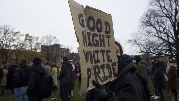 A woman holds a placard during an anti-racism rally organized by KOZP, Kick Out Zwarte Piet, or Kick Out Black Pete, in The Hague, Netherlands, Sunday, Dec. 6, 2020.  - Sputnik International