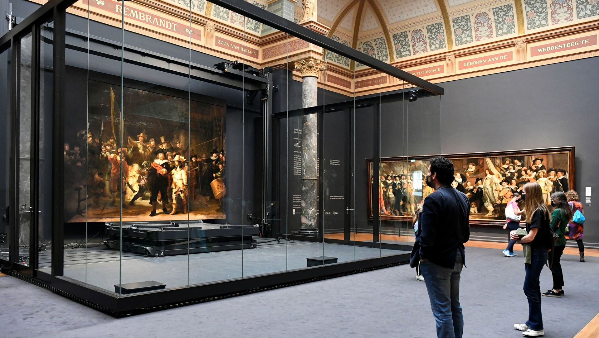 Poeple look at Rembrandt's famed Night Watch, which is back on display in what researchers say in its original size, with missing parts temporarily restored in an exhibition aided by artificial intelligence, at Rijksmuseum in Amsterdam, Netherlands June 23, 2021. Poeple look at Rembrandt's famed Night Watch, which is back on display in what researchers say in its original size, with missing parts temporarily restored in an exhibition aided by artificial intelligence, at Rijksmuseum in Amsterdam, Netherlands June 23, 2021. - Sputnik International, 1920, 25.06.2021