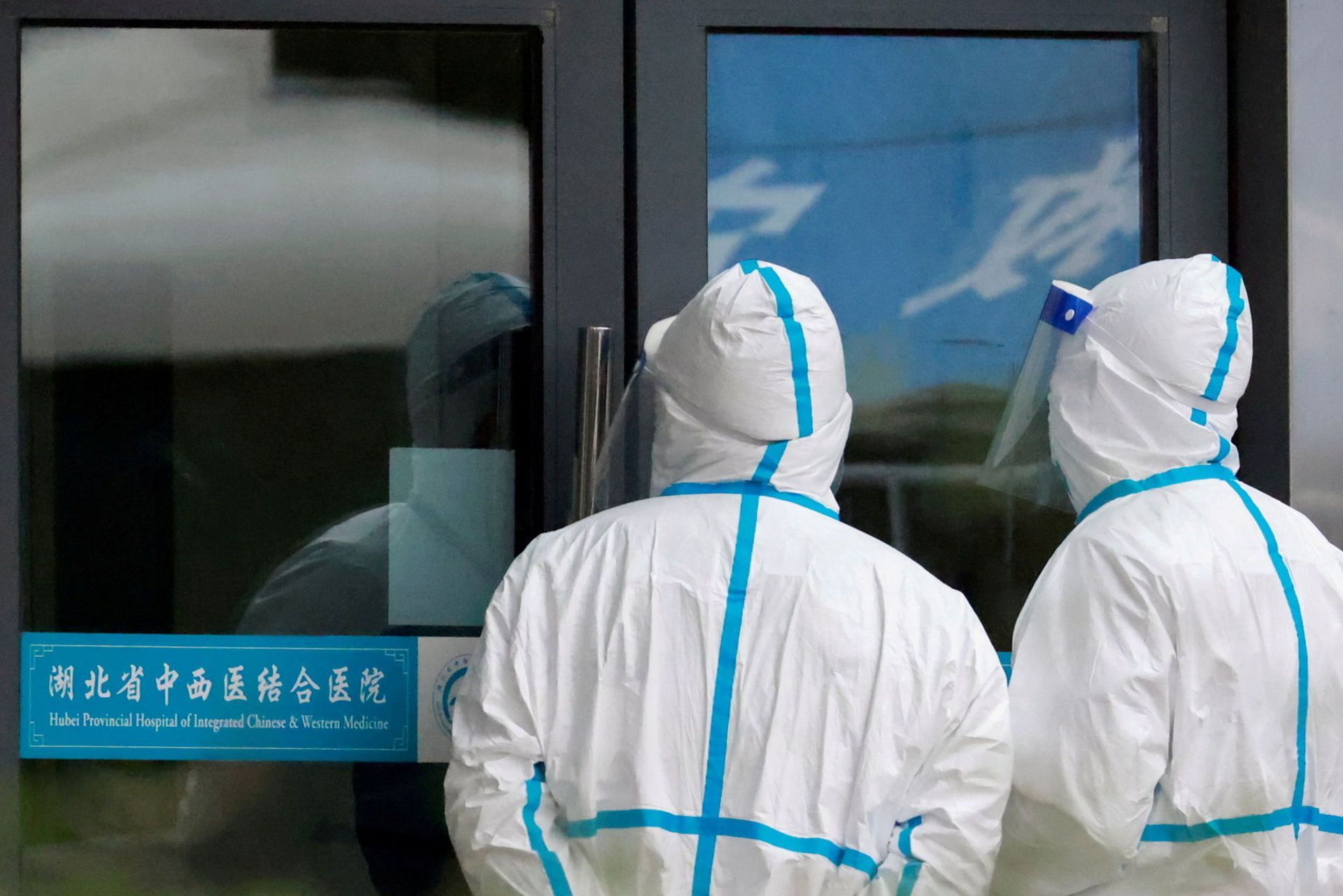 Staff members in protective suits stand at Hubei Provincial Hospital of Integrated Chinese and Western Medicine where members of the World Health Organization (WHO) team tasked with investigating the origins of the coronavirus disease (COVID-19) are visiting, in Wuhan, Hubei province, China January 29, 2021. - Sputnik International, 1920, 07.09.2021