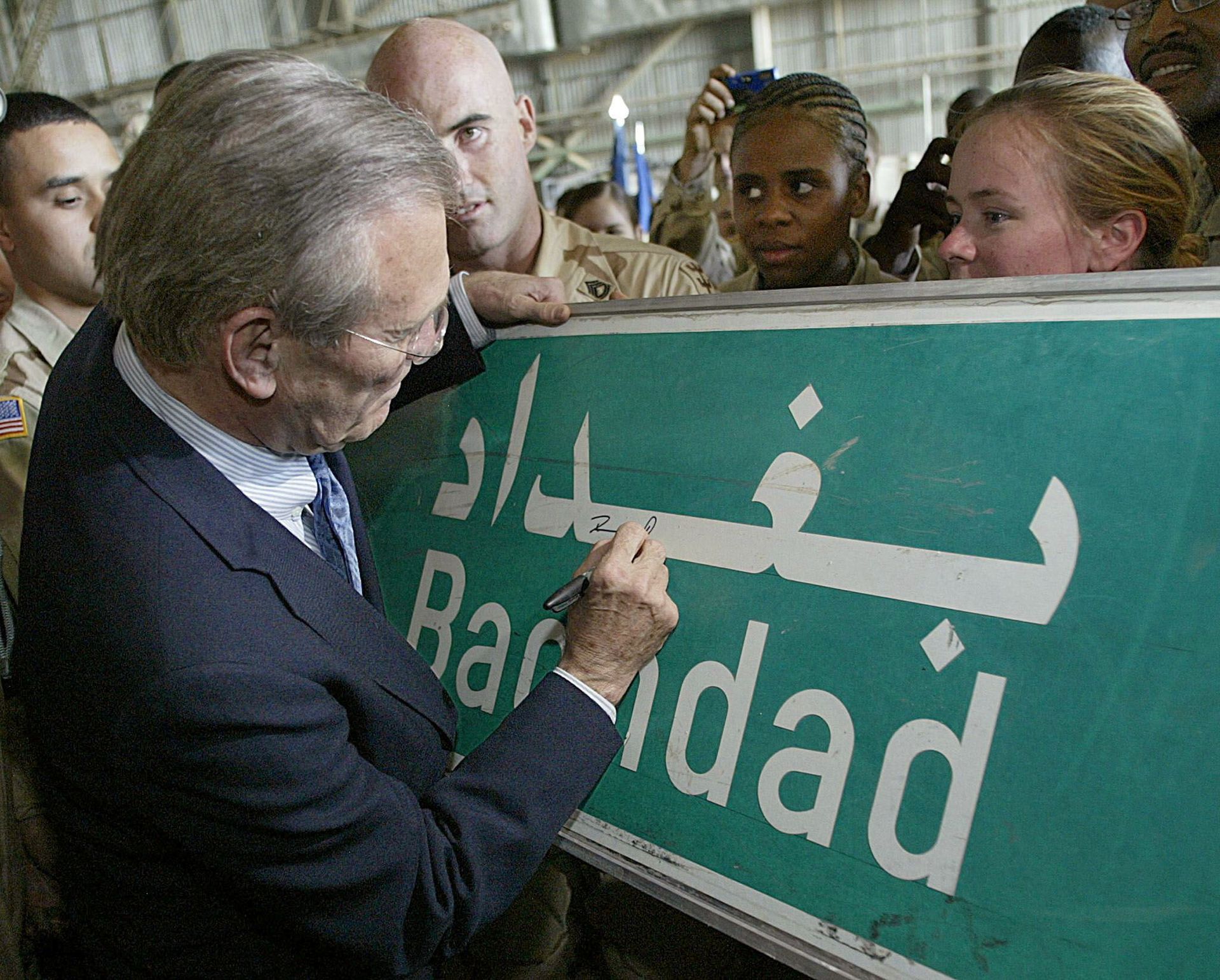 U.S. Secretary of Defence Donald Rumsfeld (C) signs a Baghdad road sign at the request of a US soldier April 30, 2003 during his visit to US troops at Baghdad's international airport. U.S. Secretary of Defence Donald Rumsfeld (C) signs a Baghdad road sign at the request of a US soldier April 30, 2003 during his visit to US troops at Baghdad's international airport. - Sputnik International, 1920, 07.09.2021