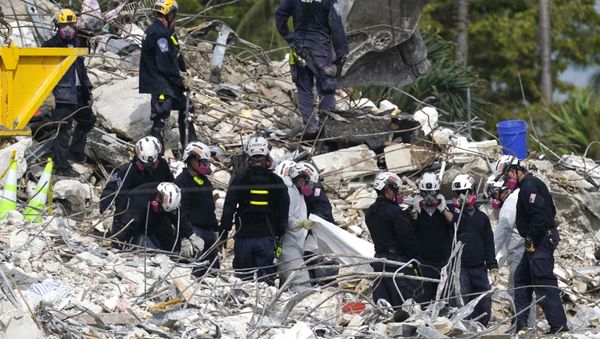 Rescue workers use a tarp for recovered remains at the site of the collapsed Champlain Towers South condo building, Monday, July 5, 2021 in Surfside, Fla. - Sputnik International