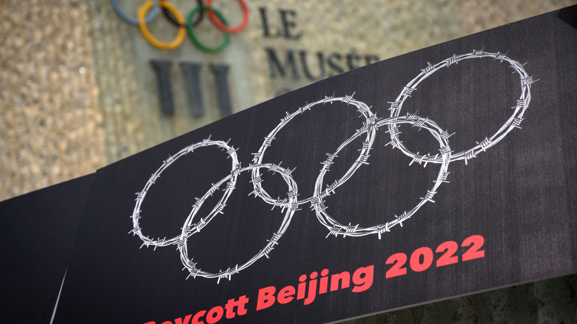 This photograph taken on June 23, 2021 shows a placard representing barber wire shaping and Olympics Rings are seen next to a sign of the Olympics Museum during a protest organised by Tibetan and Uyghur activists against Beijing 2022 Winter Olympics, in Lausanne as some 200 participants took part to the protest.  - Sputnik International, 1920, 07.07.2021