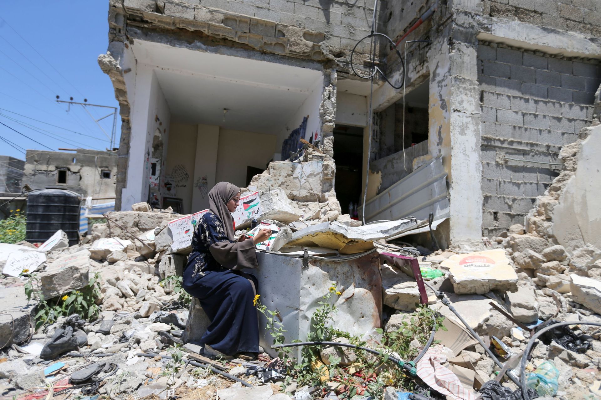 Palestinian artist Saja Mousa, 26, paints at the remains of her house that was damaged in an Israeli airstrike during last month's Israeli-Hamas fighting, in Rafah in the southern Gaza Strip June 23, 2021. Picture taken June 23, 2021. - Sputnik International, 1920, 07.09.2021