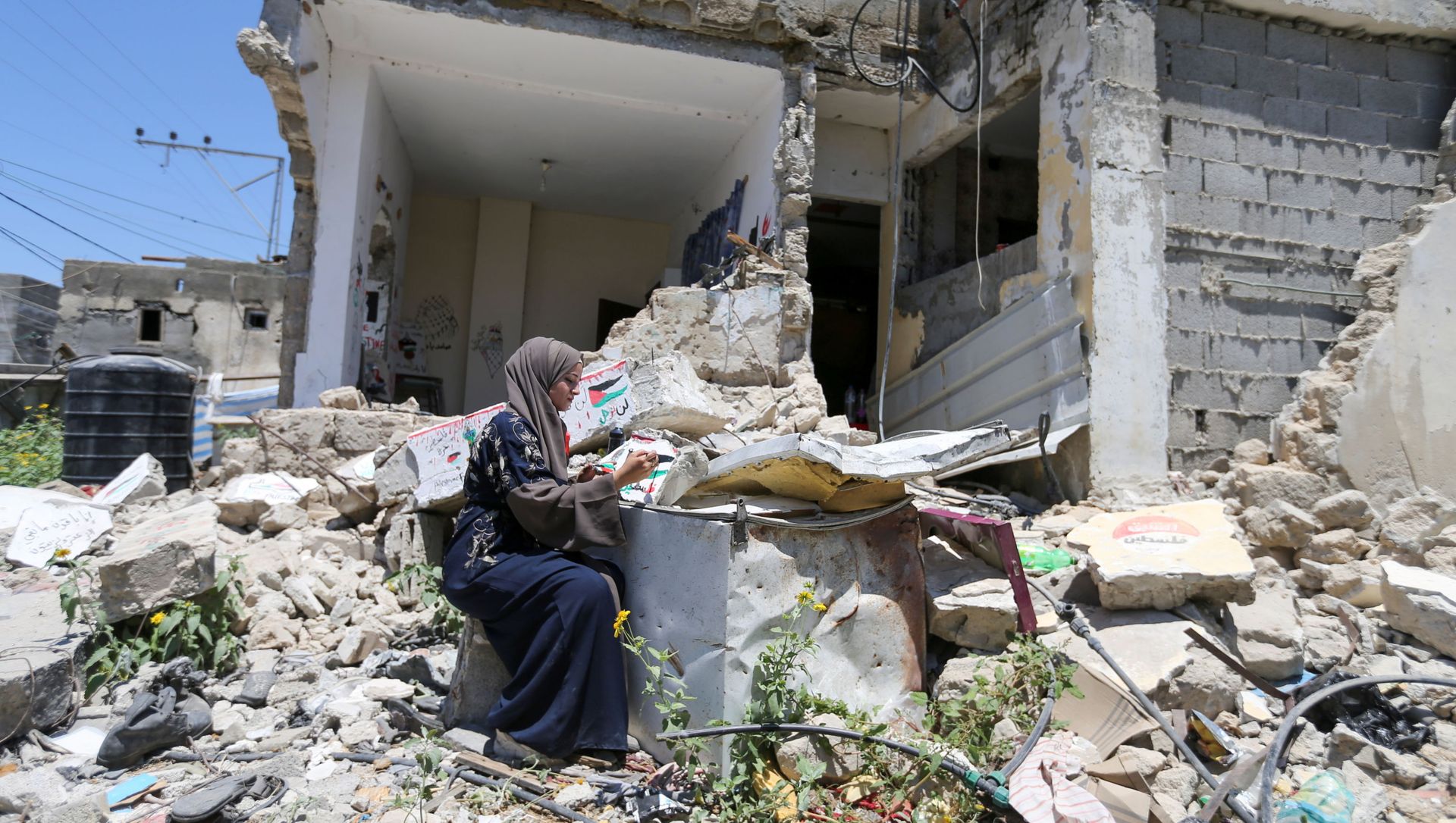 Palestinian artist Saja Mousa, 26, paints at the remains of her house that was damaged in an Israeli airstrike during last month's Israeli-Hamas fighting, in Rafah in the southern Gaza Strip June 23, 2021. Picture taken June 23, 2021. - Sputnik International, 1920, 07.07.2021
