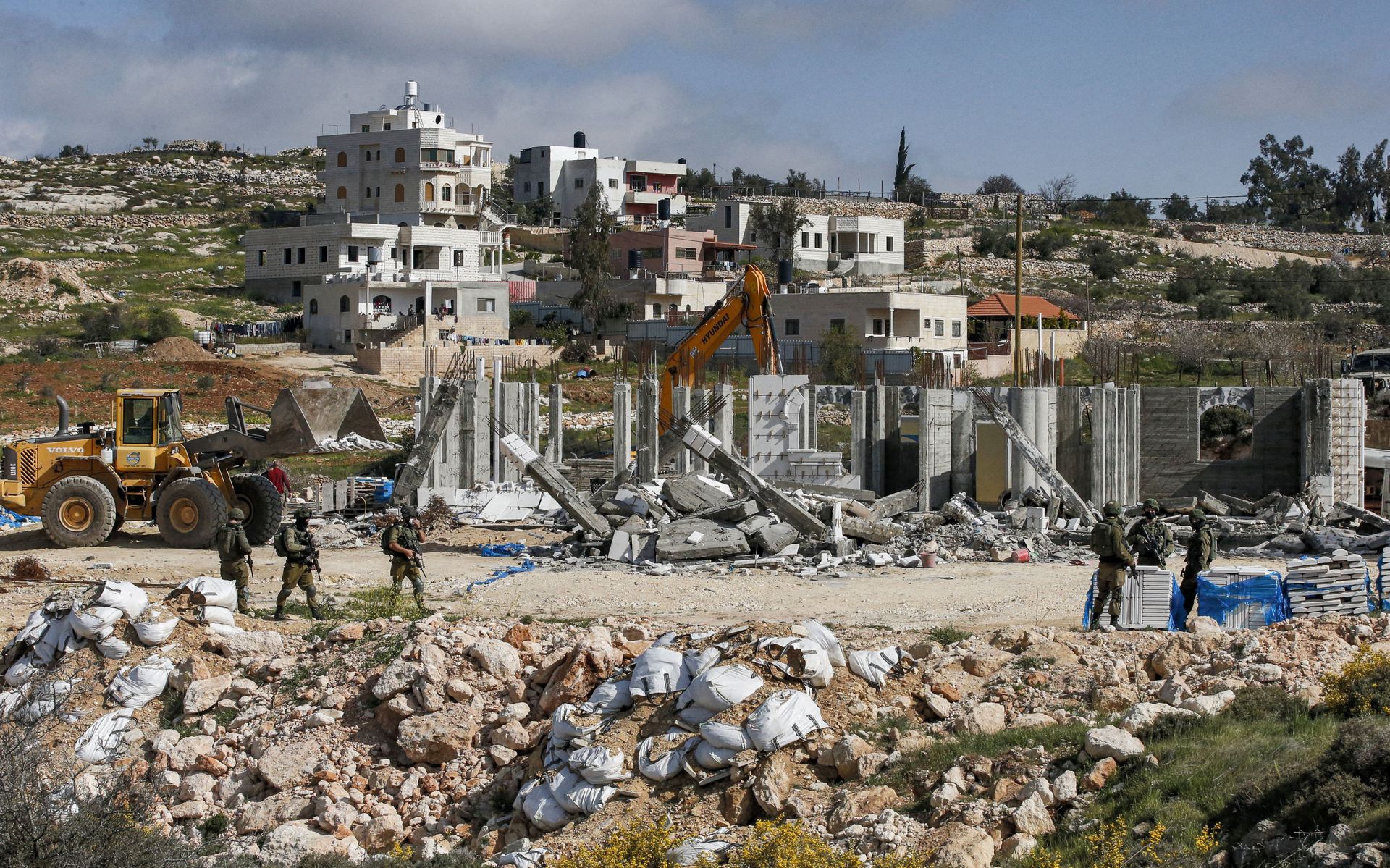 Israeli soldiers stand by as excavators demolish a Palestinian house (still under construction) located within the area C (where Israel retains full control over planning and construction) southeast of Hebron in the occupied West Bank on March 8, 2021. Israeli soldiers stand by as excavators demolish a Palestinian house (still under construction) located within the area C (where Israel retains full control over planning and construction) southeast of Hebron in the occupied West Bank on March 8, 2021. - Sputnik International, 1920, 07.09.2021