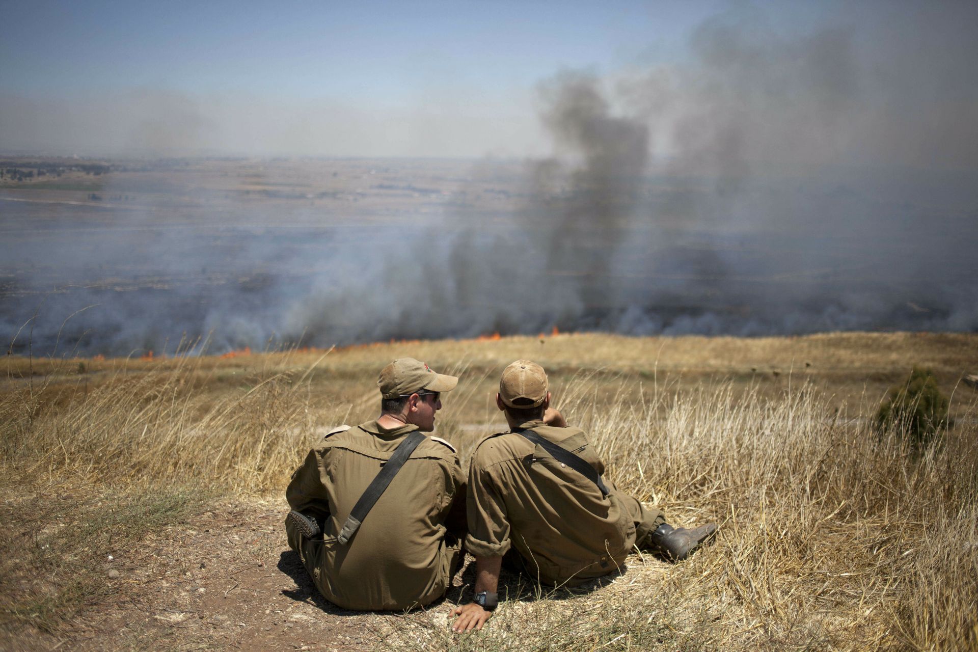 FILE - In this July 16, 2013, file photo, Israeli soldiers sit in a position on the border with Syria on the Israeli-controlled Golan Heights as smoke rises following explosions of mortar shells FILE - In this July 16, 2013, file photo, Israeli soldiers sit in a position on the border with Syria on the Israeli-controlled Golan Heights as smoke rises following explosions of mortar shells - Sputnik International, 1920, 07.09.2021