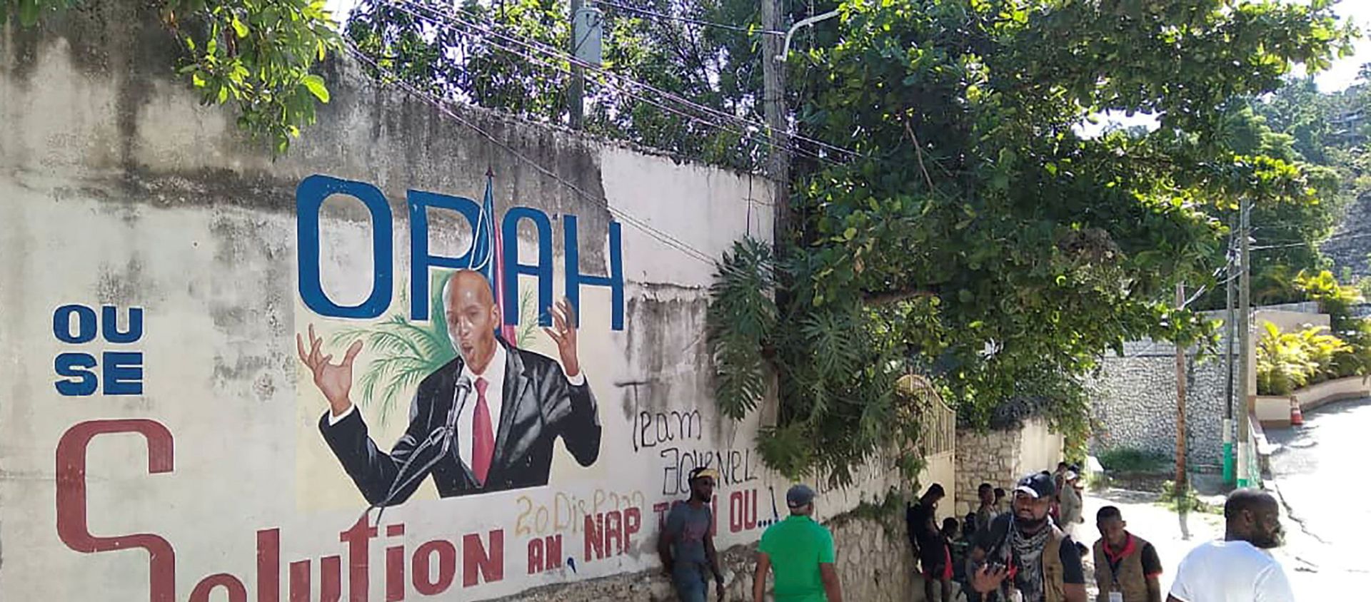 People walk past a wall with a mural depicting Haiti's President Jovenel Moise, after he was shot dead by unidentified attackers in his private residence, in Port-au-Prince, Haiti July 7, 2021.  - Sputnik International, 1920, 08.07.2021