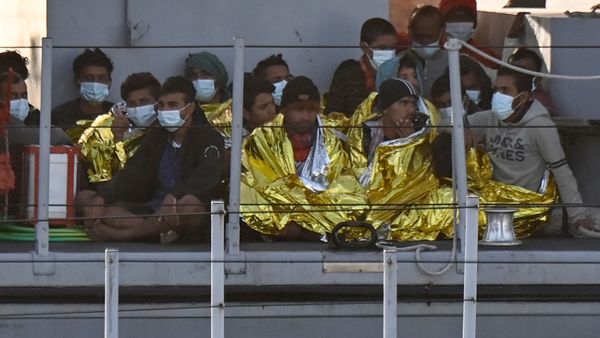 Migrants warmed by emergency blankets arrive on a boat of the Italian Guardia Di Finanza law enforcement agency on May 17, 2021 to disembark on the southern Italian Pelagie Island of Lampedusa. - More than 1,400 migrants arrived on the Italian island of Lampedusa at the weekend, sparking calls from far-right politicians for action to stem the flow, amid fresh moves by Italian authorities against the rescue boats who operate in the central Mediterranean. - Sputnik International