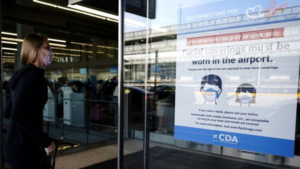 A traveler walks in Terminal 3 as a sign stating face coverings are required is displayed at O'Hare International Airport in Chicago, Friday, July 2, 2021. The World Health Organization is encouraging even the vaccinated to keep masks on, particularly indoors, as the delta variant of COVID-19 ricochets around the world. - Sputnik International