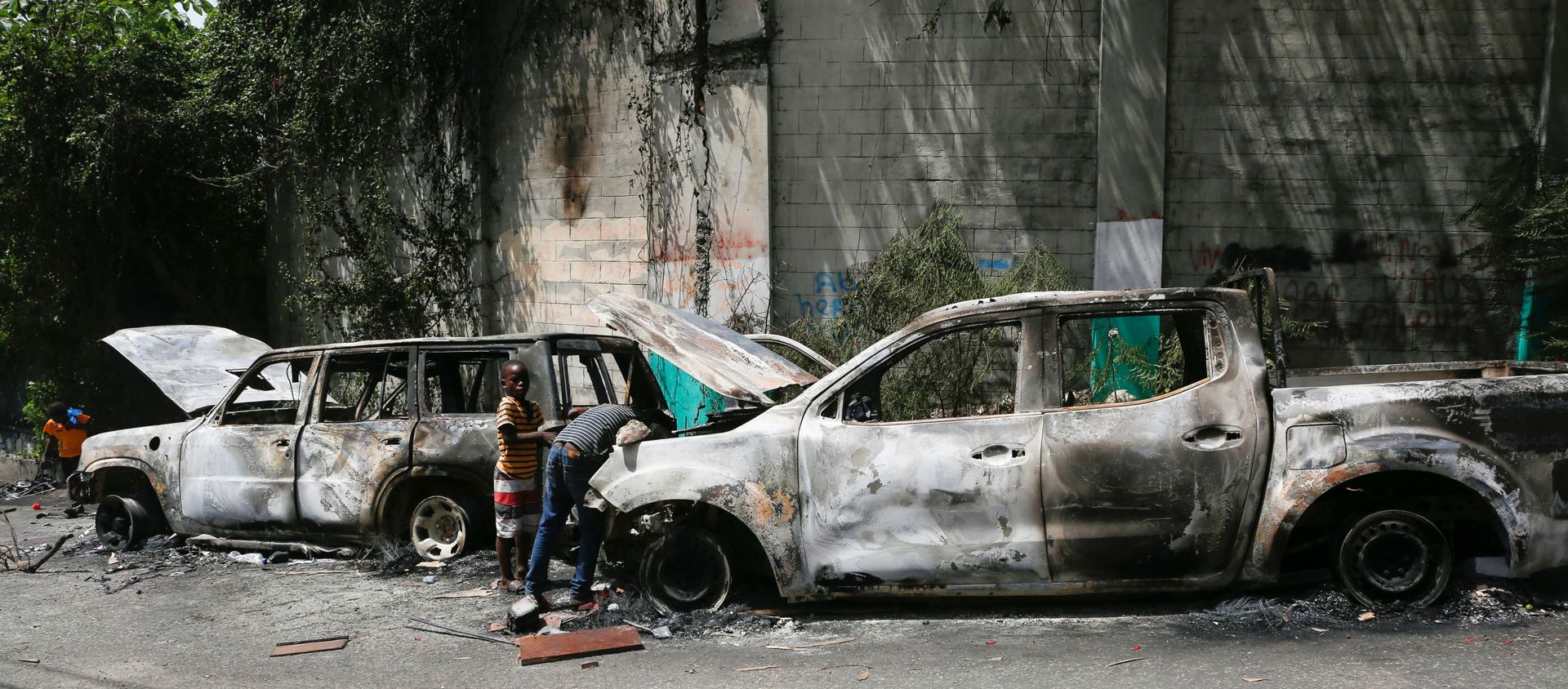 Children look for metal pieces in cars burnt by locals after a firefight between police and the suspected assassins of President Jovenel Moise who was shot dead early Wednesday at his home, in Port-au-Prince, Haiti July 8, 2021. - Sputnik International, 1920, 08.07.2021