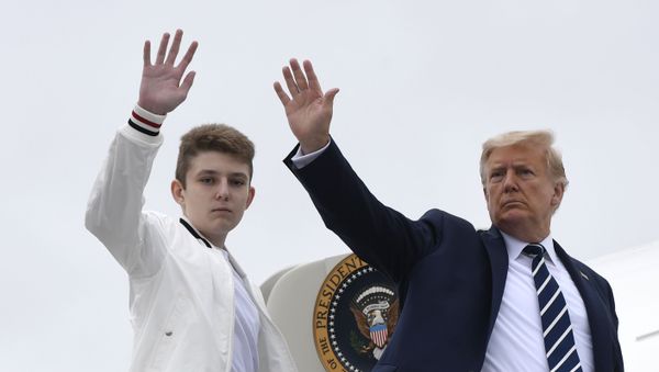 In this Aug. 16, 2020 file photo, President Donald Trump, right, and his son Barron Trump wave from the top of the steps to Air Force One at Morristown Municipal Airport in Morristown, N.J. - Sputnik International