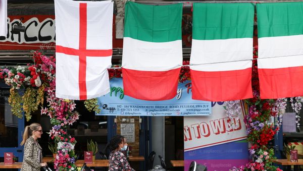 People walk past a restaurant displaying Italy and England flags, in London, Britain, 9 July 2021. People walk past a restaurant displaying Italy and England flags, in London, Britain, 9 July 2021. - Sputnik International