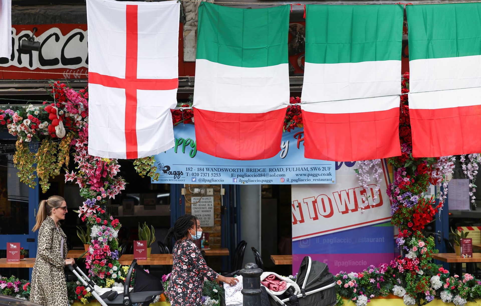 People walk past a restaurant displaying Italy and England flags, in London, Britain, July 9, 2021. People walk past a restaurant displaying Italy and England flags, in London, Britain, July 9, 2021. - Sputnik International, 1920, 07.09.2021