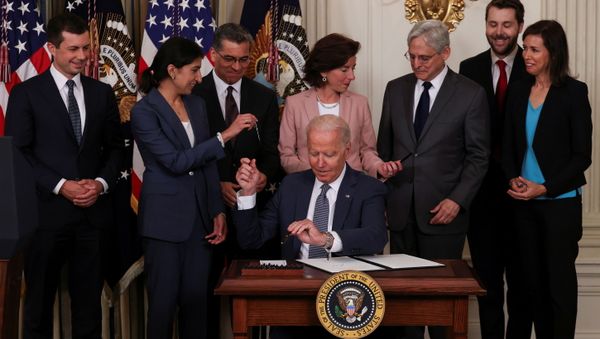 U.S. President Joe Biden hands a pen to Lina Khan, chair of the Federal Trade Commission, while signing an executive order on promoting competition in the American economy, as members of his Cabinet standby in the State Dining Room at the White House in Washington U.S., July 9, 2021. - Sputnik International