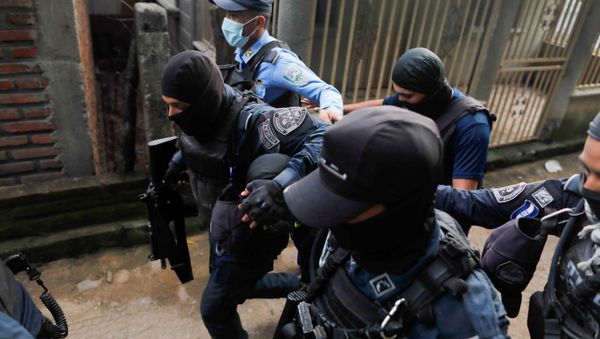 Honduran police officers detain a man on suspicion for his role in killing Italian national Giorgio Scanu, 65, who was lynched by a mob of more than 600 villagers - Sputnik International