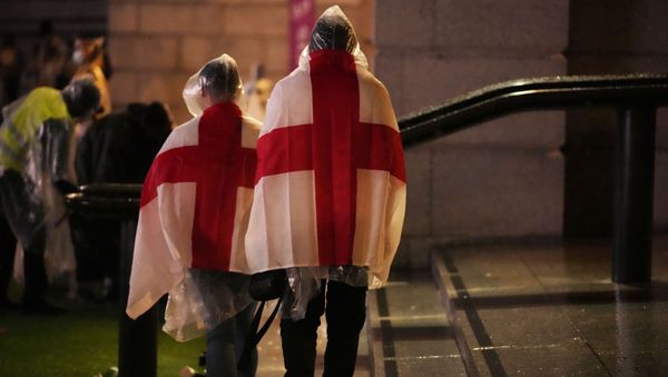 England supporters wear flags as they leave the designated fan zone at Trafalgar Square in London, Sunday, July 11, 2021, after Italy won the Euro 2020 soccer championship final match between England and Italy played at Wembley Stadium. - Sputnik International