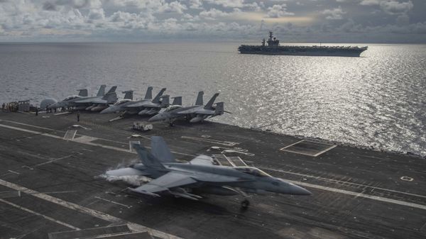 In this photo provided by U.S. Navy, an F/A-18E Super Hornet lands on the flight deck of the USS Ronald Reagan (CVN 76), as USS Nimitz (CVN 68) steams alongside in the South China Sea, Monday, July 6, 2020. - Sputnik International