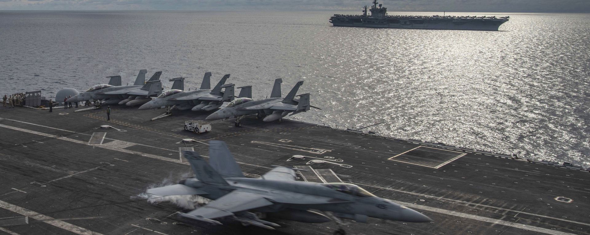 In this photo provided by U.S. Navy, an F/A-18E Super Hornet lands on the flight deck of the USS Ronald Reagan (CVN 76), as USS Nimitz (CVN 68) steams alongside in the South China Sea, Monday, July 6, 2020. - Sputnik International, 1920, 07.09.2021