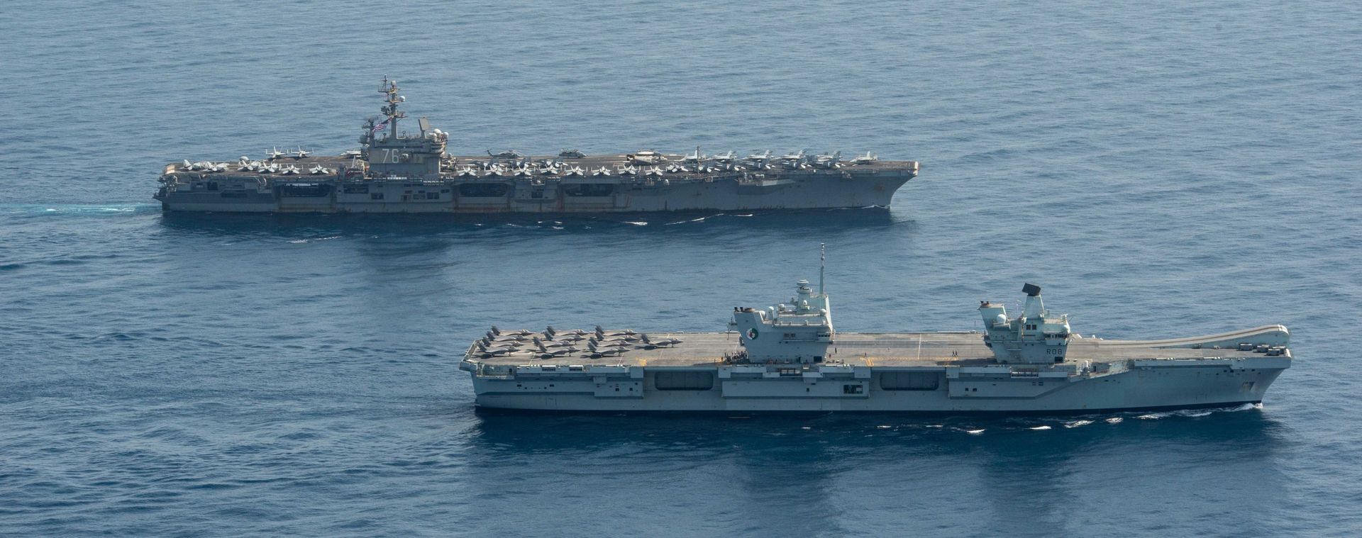 Royal Navy aircraft carrier HMS Queen Elizabeth ( R 08), front, and aircraft carrier USS Ronald Reagan (CVN 76) operate in formation in the Gulf of Aden, July 12. Royal Navy aircraft carrier HMS Queen Elizabeth ( R 08), front, and aircraft carrier USS Ronald Reagan (CVN 76) operate in formation in the Gulf of Aden, July 12. - Sputnik International, 1920, 07.09.2021