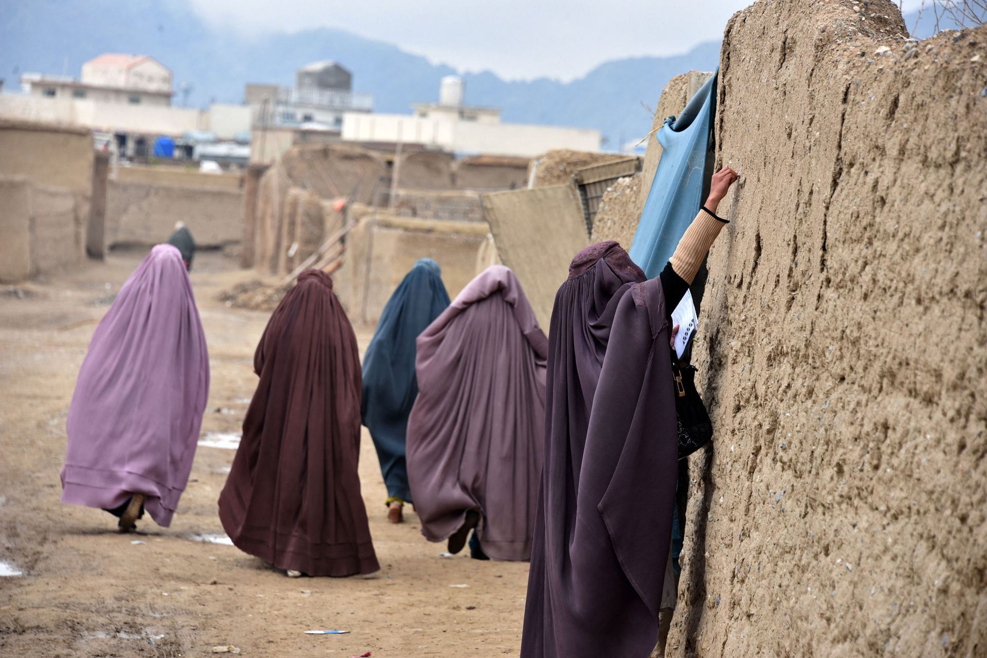 A burqa-clad woman of polio immunisation team writes a message on the wall of a house during a vaccination campaign in Kandahar on January 28, 2020 - Sputnik International, 1920, 07.09.2021