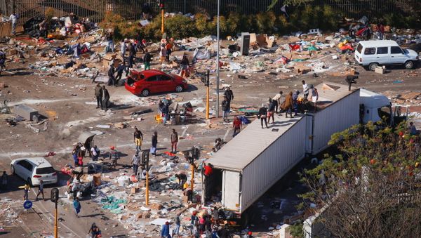 People loot an area near a burning warehouse after violence erupted following the jailing of former South African President Jacob Zuma, in Durban, South Africa, July 14, 2021. - Sputnik International