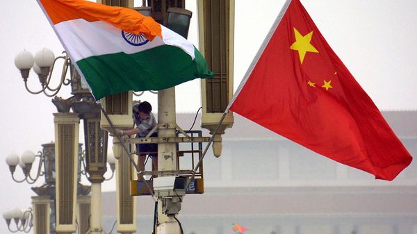 Workers put up the Indian flag (L) alongside the Chinese flag on Tiananmen Square in Beijing, 22 June 2003 - Sputnik International