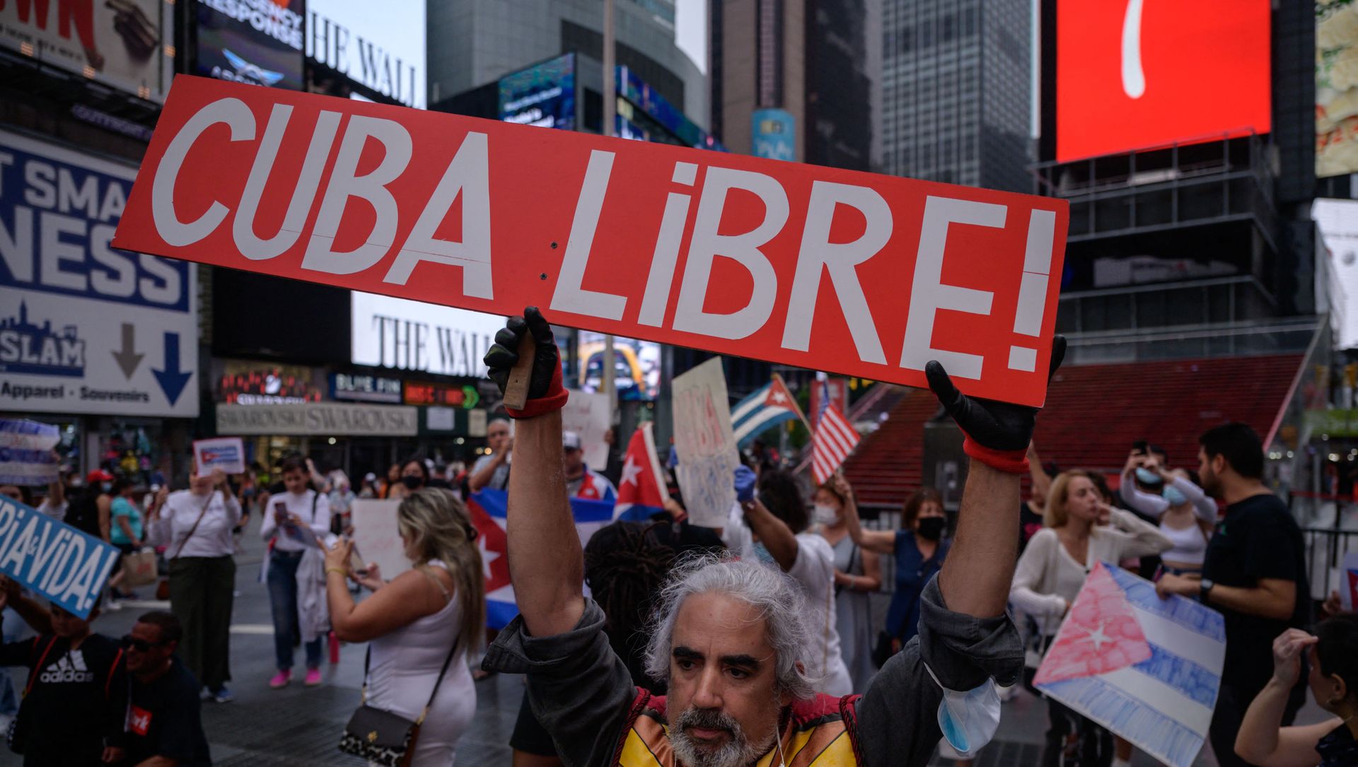 Demonstrators hold placards during a rally held in solidarity with anti-government protests in Cuba, in Times Square, New York on July 13, 2021. - One person died and more than 100 others, including independent journalists and dissidents, have been arrested after unprecedented anti-government protests in Cuba, with some remaining in custody on Tuesday, observers and activists said. Demonstrators hold placards during a rally held in solidarity with anti-government protests in Cuba, in Times Square, New York on July 13, 2021. - One person died and more than 100 others, including independent journalists and dissidents, have been arrested after unprecedented anti-government protests in Cuba, with some remaining in custody on Tuesday, observers and activists said. - Sputnik International, 1920, 17.07.2021