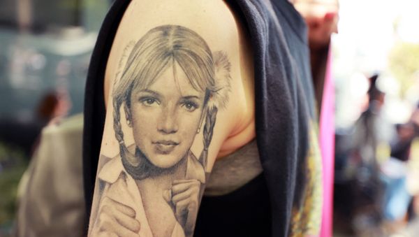 A protester with a Britney Spears tattoo attends a #FreeBritney Rally at Stanley Mosk Courthouse on July 14, 2021 in Los Angeles, California. The group is calling for an end to the 13-year conservatorship lead by the pop star's father, Jamie Spears and Jodi Montgomery, who have control over her finances and business dealings. Planned co-conservator Bessemer Trust is petitioning the court to resign from its position after Britney Spears spoke out in court about the conservatorship.  - Sputnik International