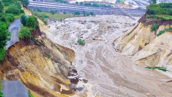 A photo taken on July 15, 2021 shows water from the overflooded river Inde flowing into the opencast mine in Inden, western Germany, following heavy rains. - On July 15, the flood-carrying river Inde flooded a dike near the mine in Inden near Aachen and flowed into the mine. Heavy rains and floods lashing western Europe have killed at least 59 people in Germany and eight in Belgium, and many more people are missing as rising waters caused several houses to collapse. - Sputnik International