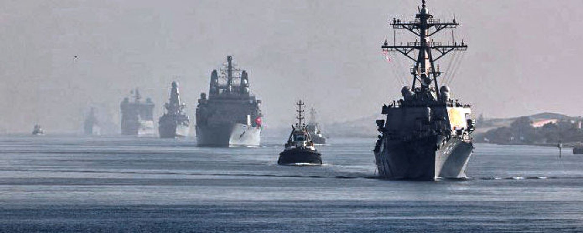 This handout image provided by the official Twitter account of Commodore Steve Moorhouse, Royal Navy, Commander of the UK Carrier Strike Group on July 6, 2021 shows a view of the vessels of the strike group sailing behind the Royal Navy's HMS Queen Elizabeth aircraft carrier through Egypt's Suez Canal. This handout image provided by the official Twitter account of Commodore Steve Moorhouse, Royal Navy, Commander of the UK Carrier Strike Group on July 6, 2021 shows a view of the vessels of the strike group sailing behind the Royal Navy's HMS Queen Elizabeth aircraft carrier through Egypt's Suez Canal. - Sputnik International, 1920, 13.10.2021
