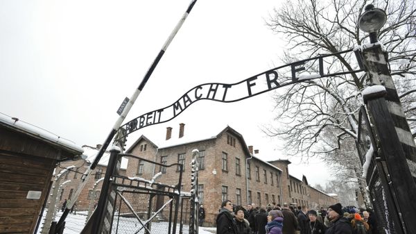 Visitors and media stand by the entrance gate of the Auschwitz Nazi death camp in Oswiecim, Poland, Monday, Jan. 26, 2015 - Sputnik International