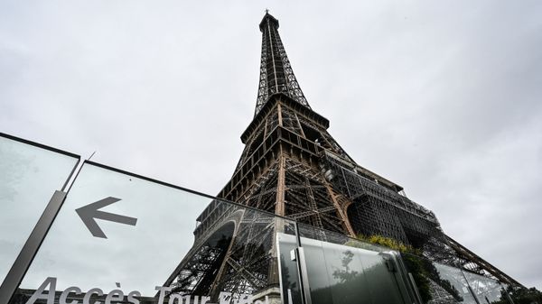 This picture taken on July 16, 2021, in Paris shows the Eiffel Tower and its protective wall. - The Eiffel Tower reopened to visitors on July 16, 2021, after nine months of shutdown caused by the Covid pandemic. Up to 13,000 people per day will be allowed to take the elevators to the top and take in the views over the French capital, down from 25,000 in the pre-Covid era.  - Sputnik International