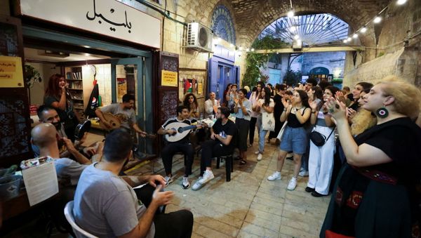 People clap as they watch musicians perform during a happening, part of an initiative launched by young Palestinians aiming to revive Nazareth's old city market, in Nazareth, northern Israel July 11, 2021.  - Sputnik International